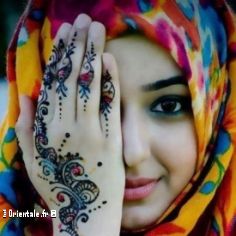 Jeune femme voile avec du henna sur la main