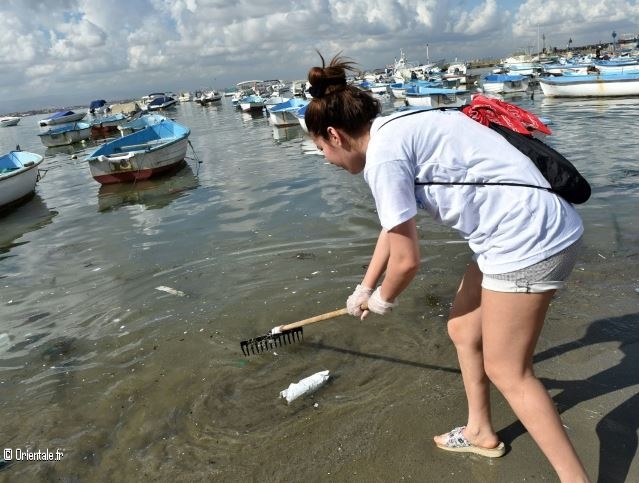 Une jeune Algrienne aide au nettoyage d'une plage d'Alger