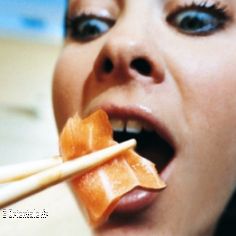 Femme mangeant un sushi au saumon