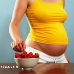 Femme enceinte choisissant une fraise