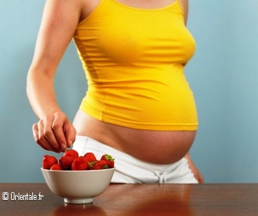 Femme enceinte choisissant une fraise