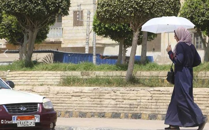 Une femme egyptienne qui porte une ombrelle Une femme egyptienne qui porte une ombrelle