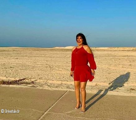 Fifi Abdou en robe rouge à la plage