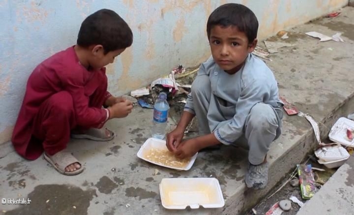 Des enfants afghans pauvres mangent ce que leur donnent les Américains