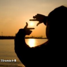 Une jeune femme qui entoure un coucher de soleil