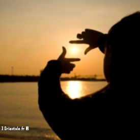Une jeune femme qui entoure un coucher de soleil