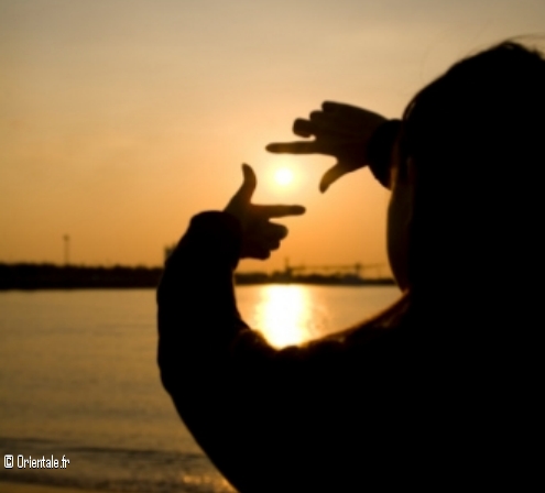 Une jeune femme qui entoure un coucher de soleil