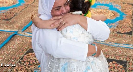 Une femme serre sa fille dans ses bras après avoir appris l'emprisonnement de son mari