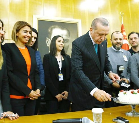 Le président turc Recep Tayyip Erdogan coupe un gâteau offert par des journalistes à l'occasion de son 65e anniversaire peu de temps avant de partir pour une tournée africaine