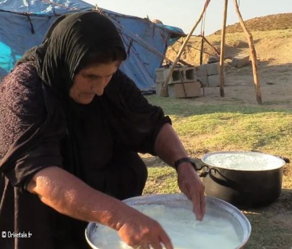 Femme d'Oman préparant du lait caillé laban