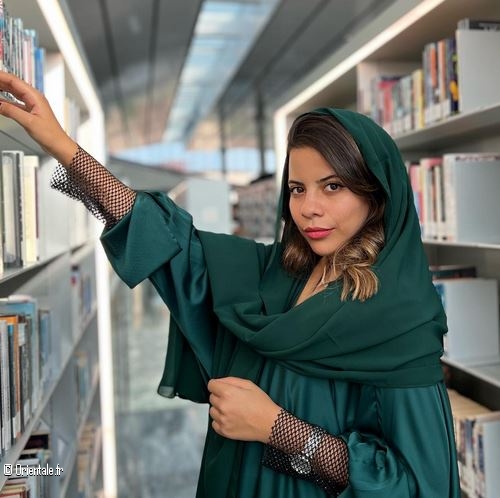 Une jeune femme parcoure les livres d'une bibliothèque
