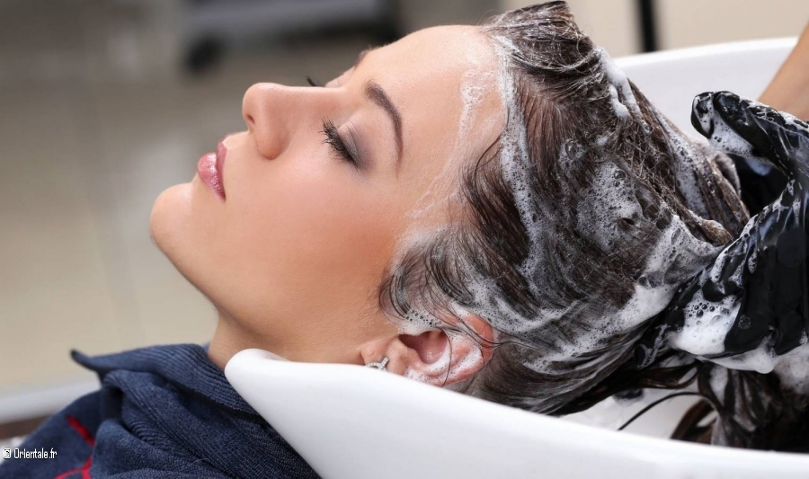 Femme qui se fait shampouiner au salon de coiffure