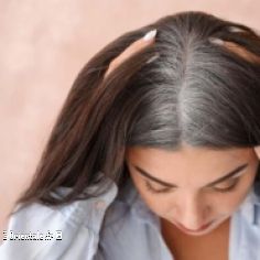 Une femme avec des racines de cheveux gris