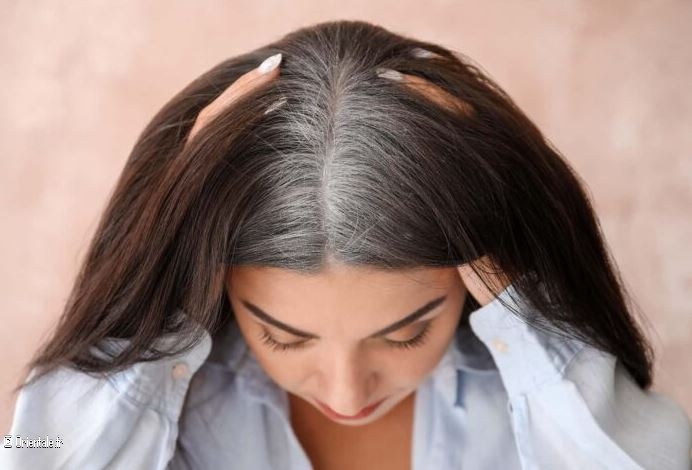 Une femme avec des racines de cheveux gris