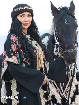 Dana Jabr devant un cheval, en tenue traditionnelle